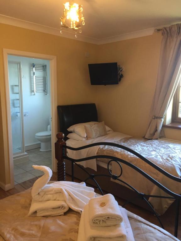 a bedroom with two beds and a bathroom with a tv at Swan House in Northallerton