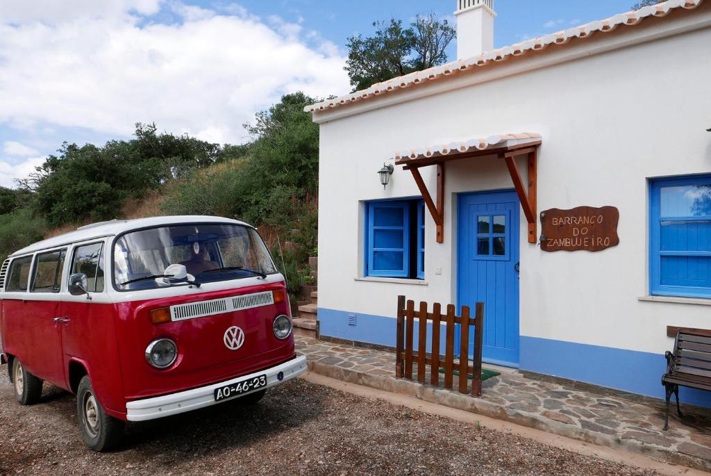 Barranco do Zambujeiro في فيلا دو بيسبو: سيارة فان حمراء متوقفة أمام منزل