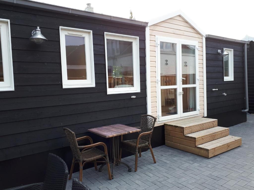 a patio with a table and chairs and a building at Vakantie bij 17 in Serooskerke