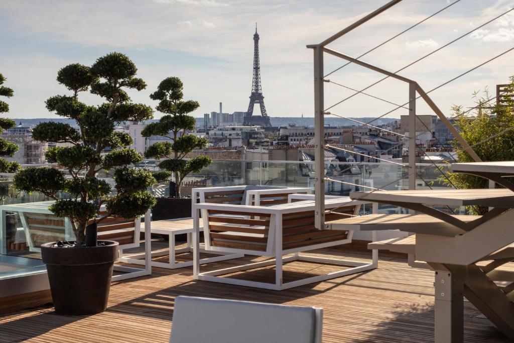 balcón con vistas a la torre Eiffel en Hotel Bowmann en París