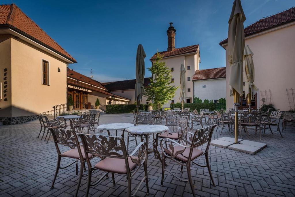 Chateau Krakovany في Krakovany: مجموعة من الطاولات والكراسي في ساحة الفناء