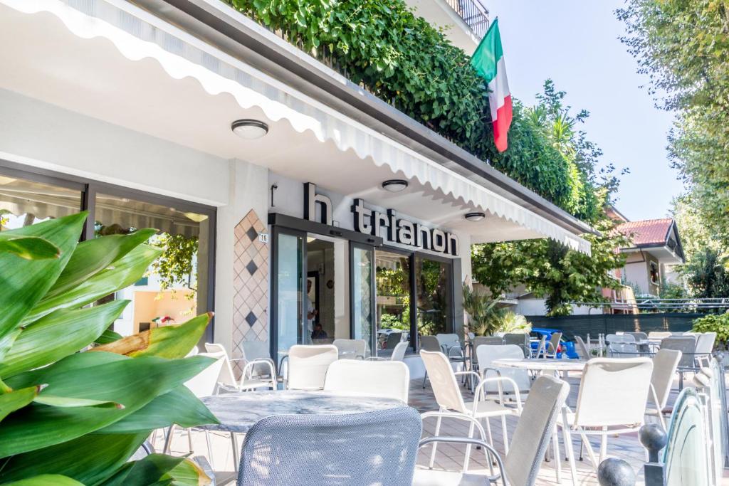 een restaurant met tafels en stoelen voor een gebouw bij Hotel Trianon in Bellaria-Igea Marina