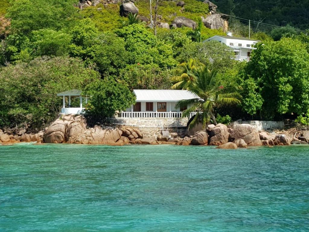 a house on a rocky island in the water at Coin D'or in Anse Possession