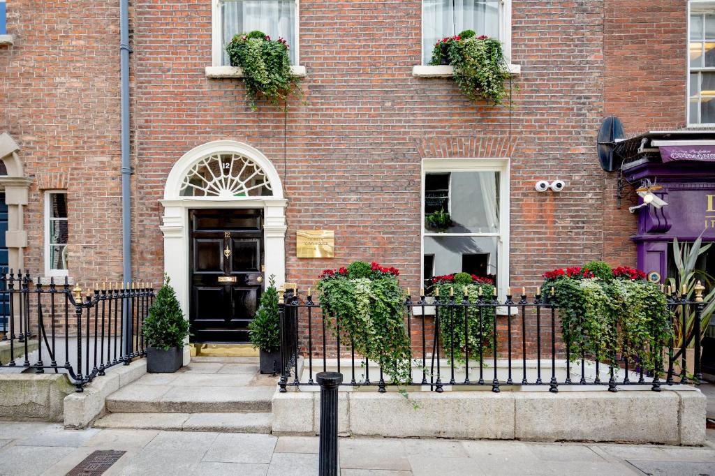 a brick building with a black fence in front of it at Trinity Townhouse Hotel in Dublin