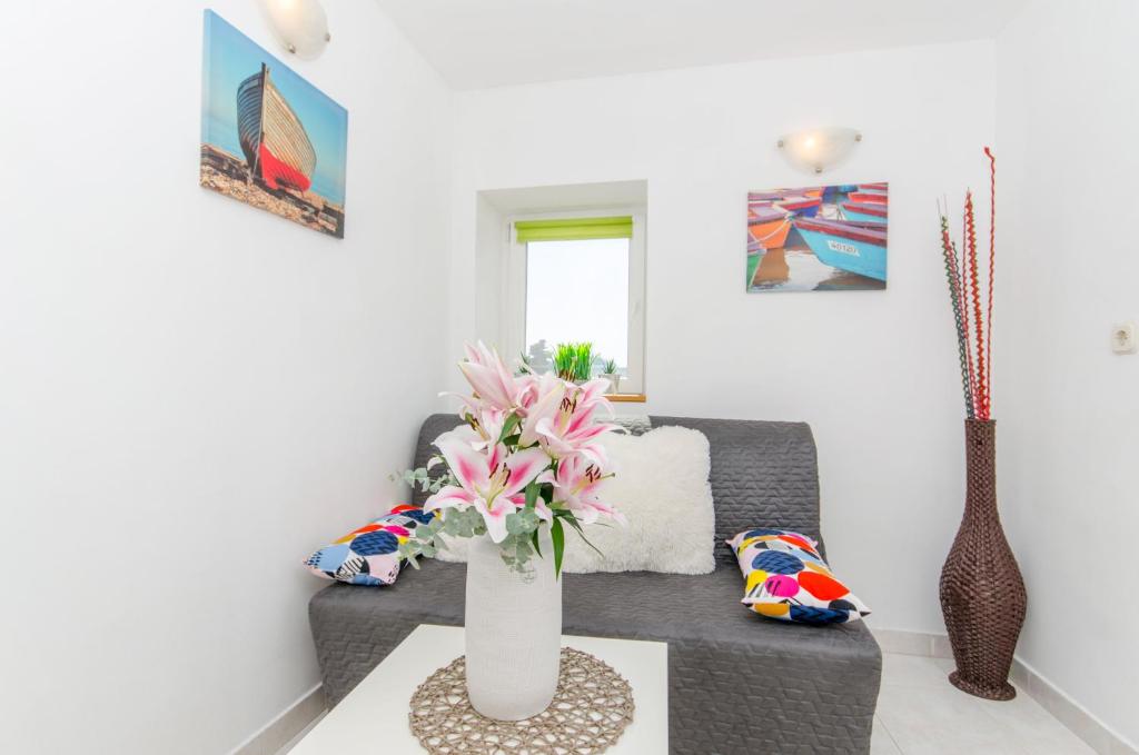 a living room with a vase of flowers on a table at Stone Rose in Center in Split