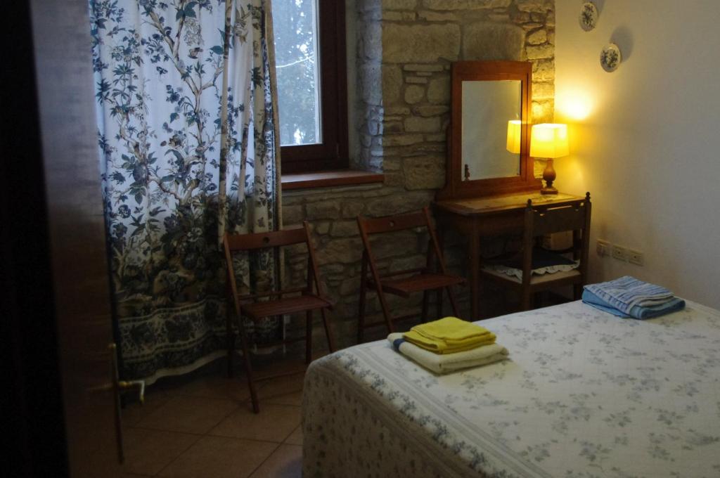 sypialnia z łóżkiem, stołem i lustrem w obiekcie Fattoria La Guedrara w mieście Sestola