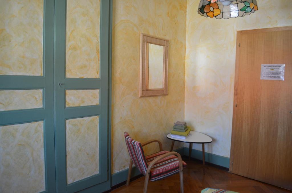 a room with a door and a table and a chair at Chambres d'Hotes Le Passiflore in Les Brenets