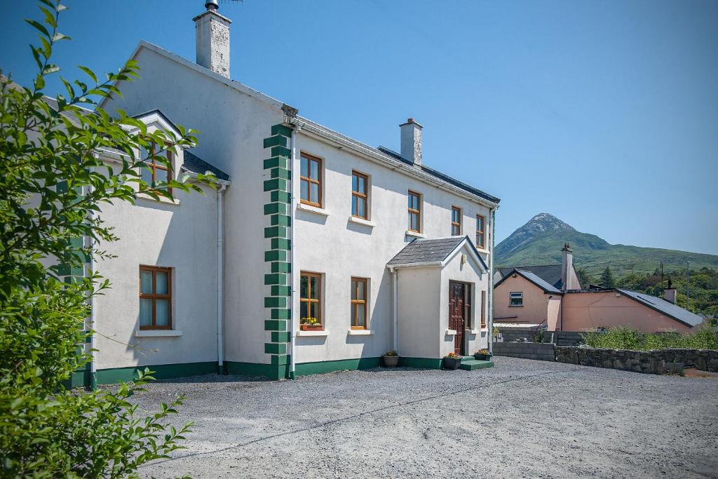 uma casa branca com uma risca verde em Cottage 182 – Letterfrack em Letterfrack