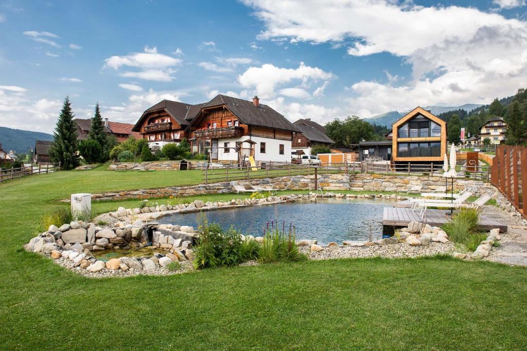 una casa grande con un estanque en el patio en Haus Christophorus en Mariapfarr