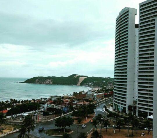 a view of a city and the ocean with a building at Vista deslumbrante para o mar em Ponta N in Natal