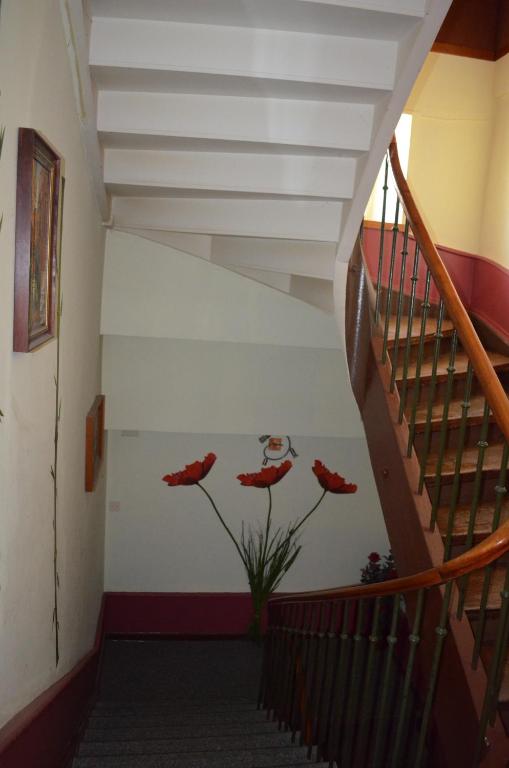 a staircase with red poppies painted on the wall at Chambres d'Hotes Le Passiflore in Les Brenets