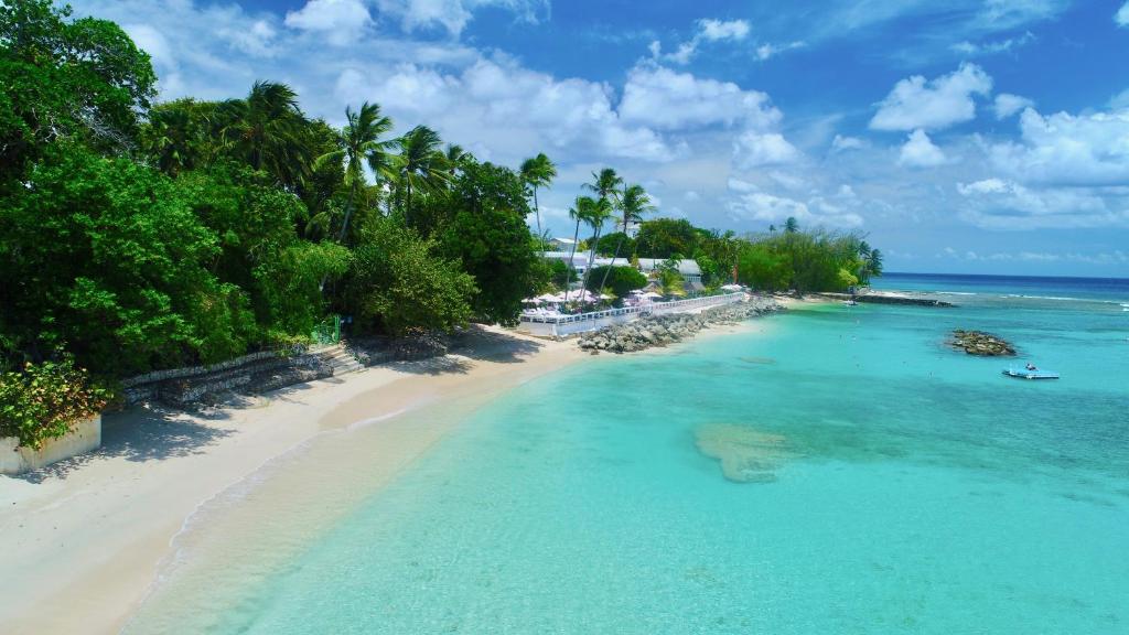 an aerial view of a beach with trees and the ocean at Cobblers Cove - Barbados in Saint Peter