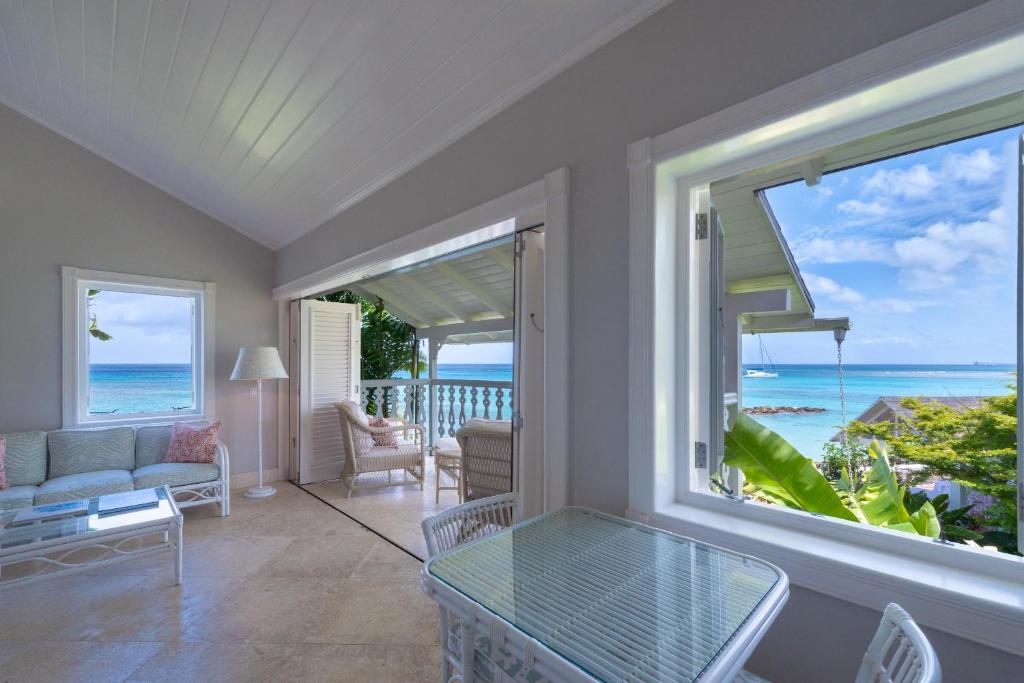 a living room with a view of the ocean at Cobblers Cove - Barbados in Saint Peter