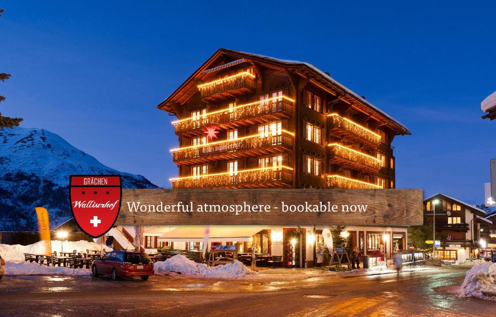 a building with a sign in front of it at Hotel Walliserhof - The Dom Collection in Grächen