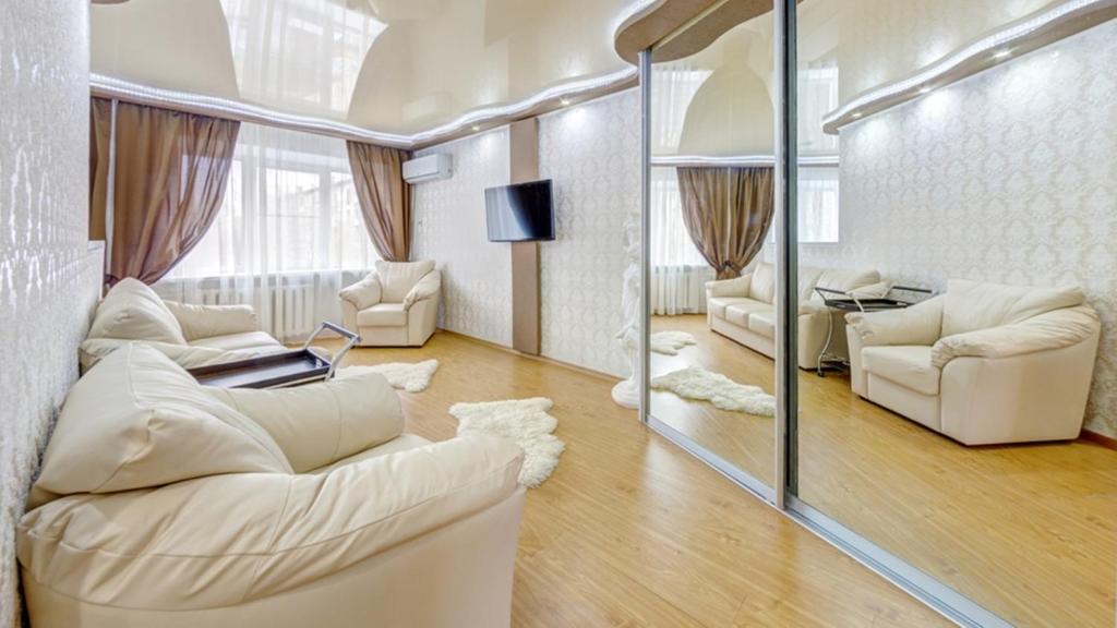 a living room with white furniture and a mirror at Апартаменты ИннХоум с джакузи у БД Спиридонов in Chelyabinsk