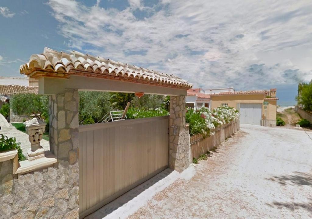 uma casa com um portão e uma cerca em Anacasa Adosado Riu Montan Deveses AD4101 em Denia