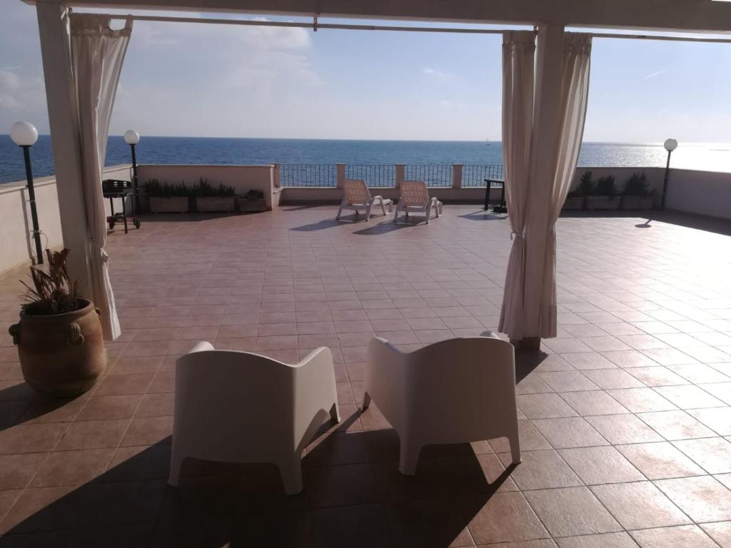 a patio with chairs and a view of the ocean at Mare d'Amuri in Porto Empedocle