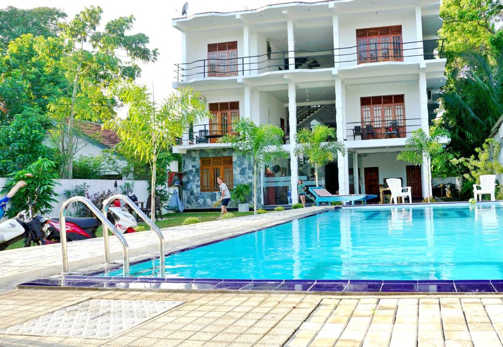 a swimming pool in front of a building at Ocean Bay Surf Resort Weligama in Weligama