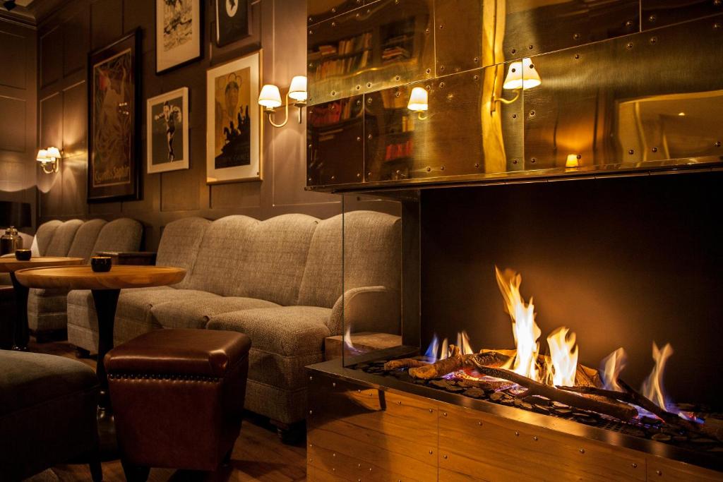 a living room with a couch and a fireplace at Monbijou Hotel in Berlin
