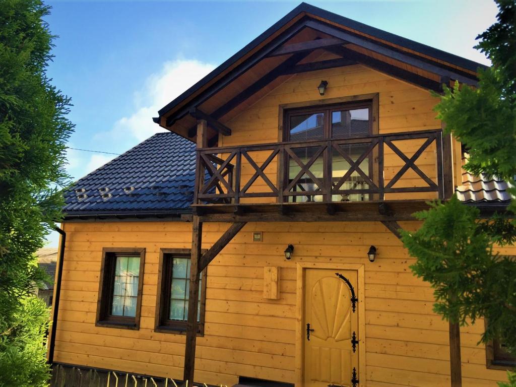 Casa de madera con balcón en la parte superior. en Dom Wypoczynkowy przy Szlaku OJCÓW, en Ojców