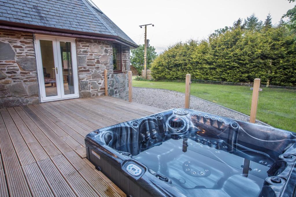 a bath tub sitting on a wooden deck at North Balkello Cottage in Dundee