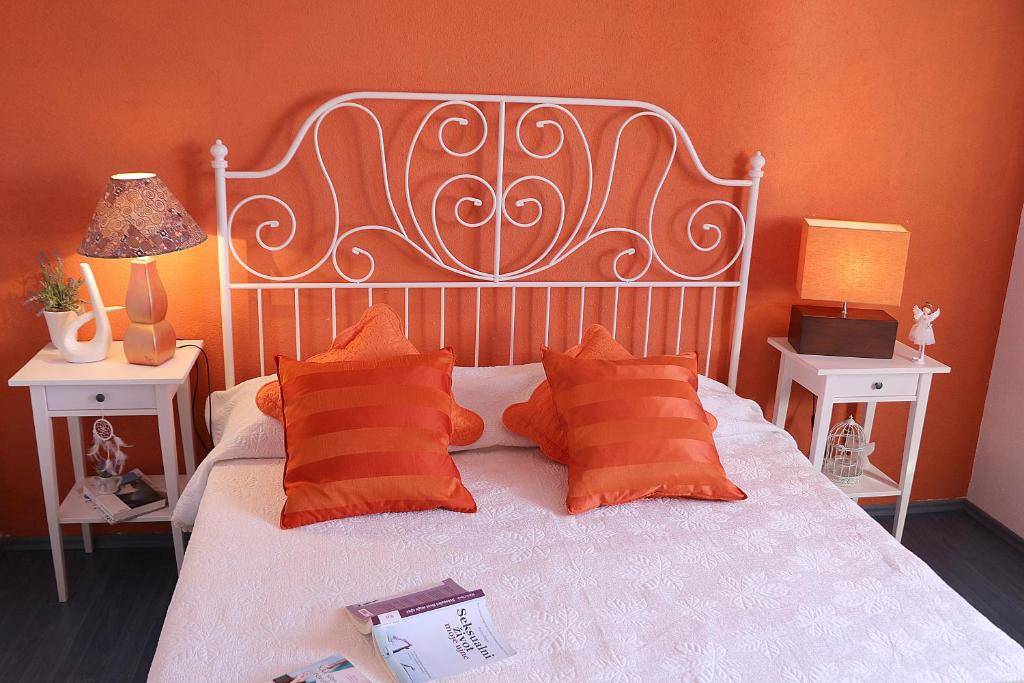 een slaapkamer met een wit bed en oranje muren bij Apartment Like Home in Gradac