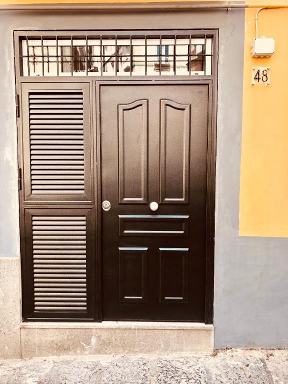 eine große schwarze Tür an der Seite eines Gebäudes in der Unterkunft Hamlet appartment in Neapel