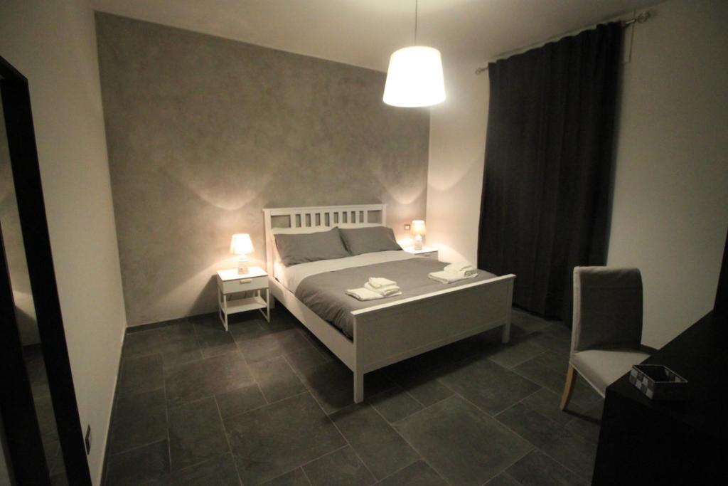 ein Schlafzimmer mit einem Bett, einer Lampe und einem Stuhl in der Unterkunft Il Rifugio degli Artisti in Varese