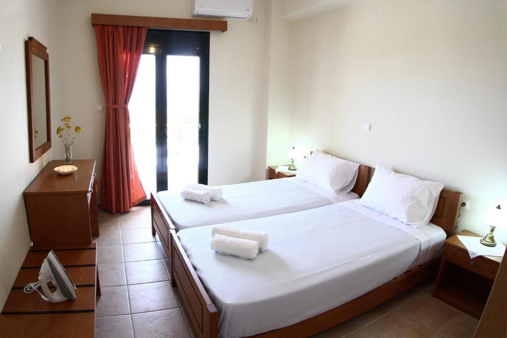a hotel room with two beds and a window at Xenios Zeus Apartments in Kissamos