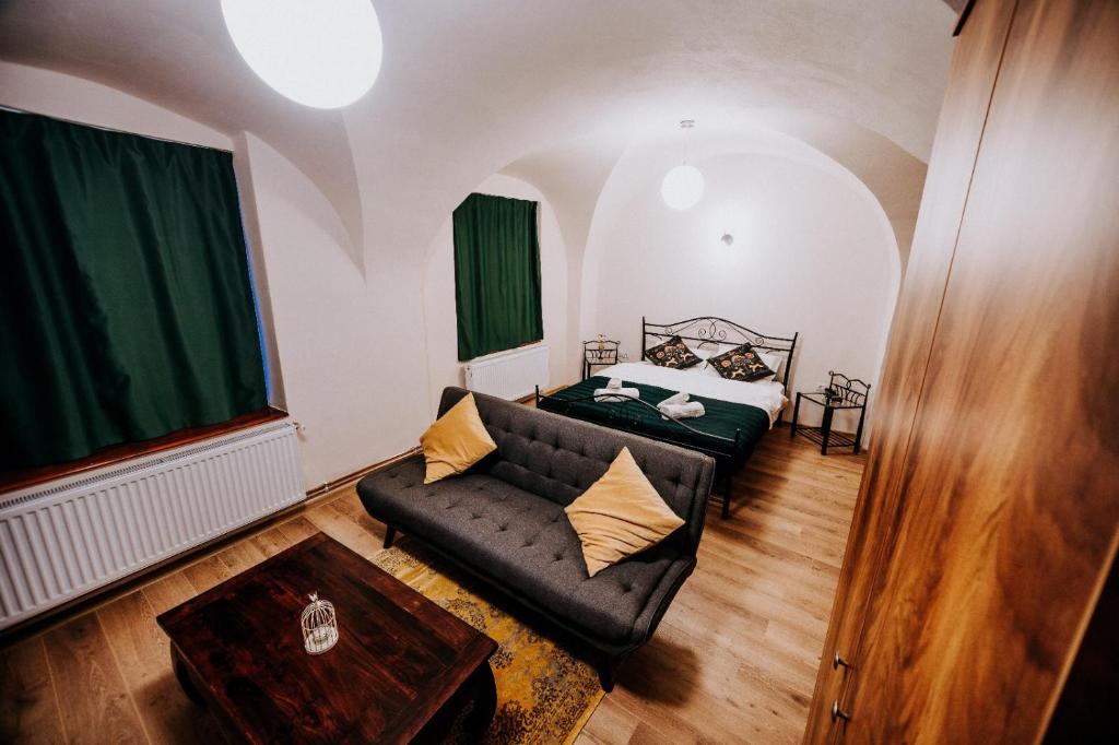 ein Wohnzimmer mit einem Sofa und einem Bett in der Unterkunft Central am Brukenthal in Sibiu