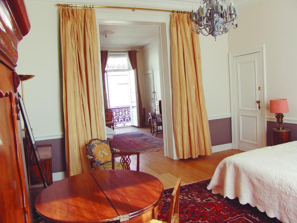 sypialnia ze stołem i łóżkiem oraz pokój w obiekcie Louise Chatelain suites w Brukseli