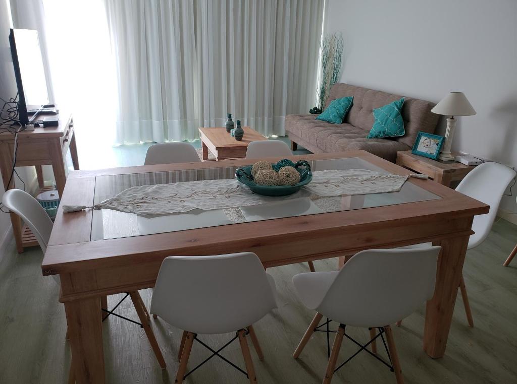 sala de estar con mesa de madera y sillas en Edificio Paquebot, en Punta del Este