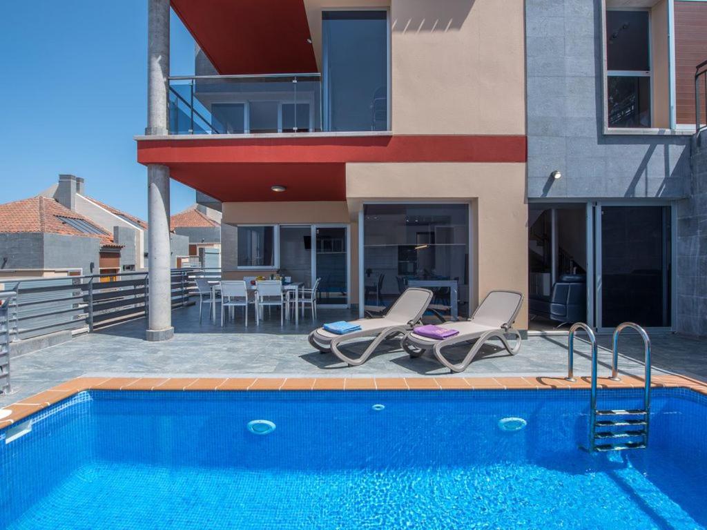 a swimming pool with two chairs and a house at Villa entera - incredible PRICE Luxury Villa Puerto De la Cruz in Santa Úrsula