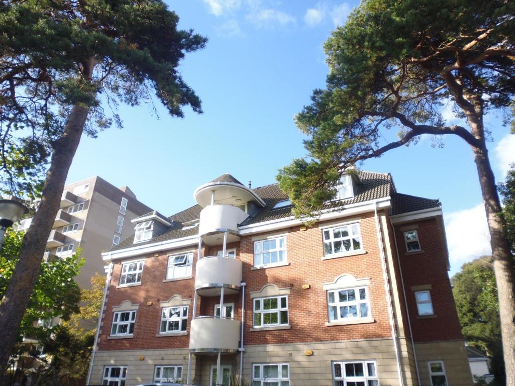 um prédio de apartamentos com árvores em frente em Walking distance to beach , close to town center em Bournemouth
