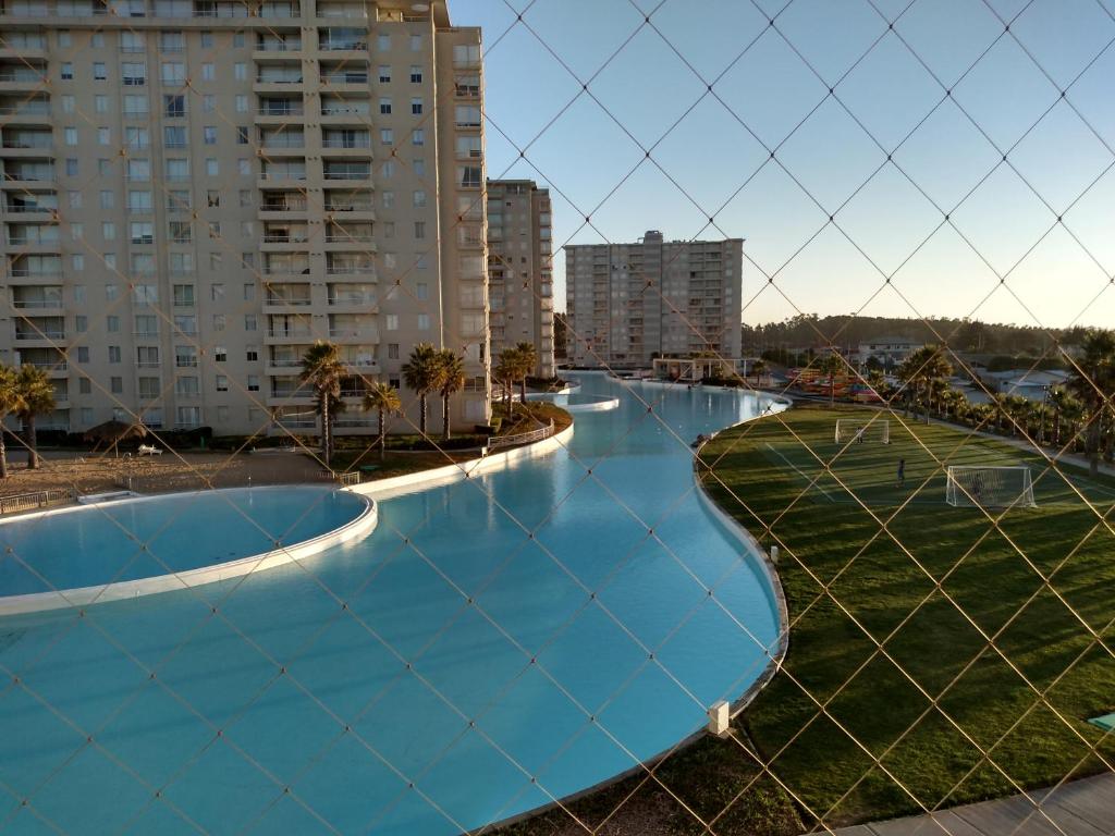 a fence with a swimming pool in a city at Condominio Laguna Vista Camino Casablanca 788 Algarrobo in Algarrobo