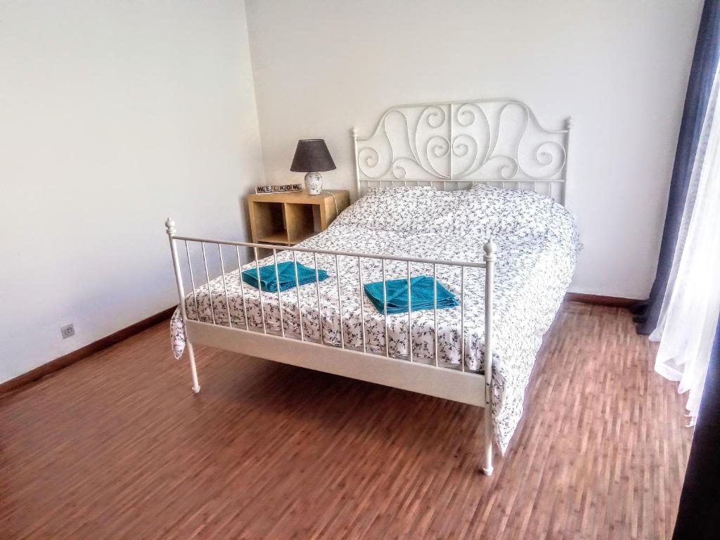 a bedroom with a white bed with blue pillows at Harmony House in Antwerp