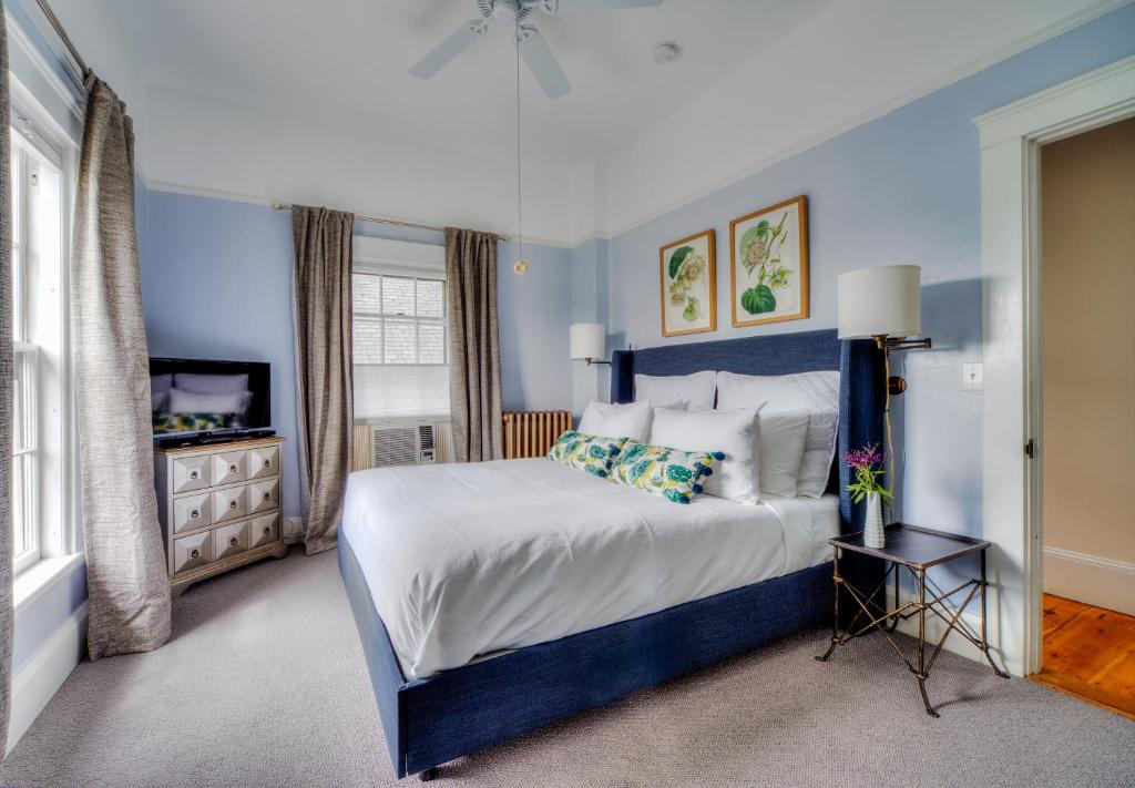 a blue bedroom with a bed and a television at The Water Street Inn in Kittery