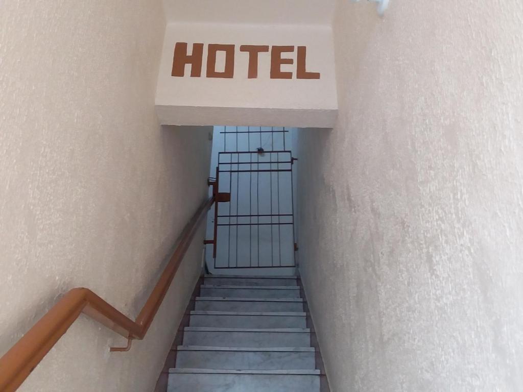 un panneau d'hôtel au-dessus d'un escalier dans un bâtiment dans l'établissement Hotel Anacleto, à São Paulo