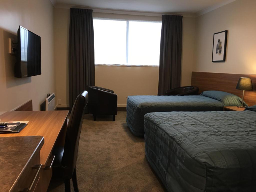 Postel nebo postele na pokoji v ubytování The Victoria Hotel Dunedin