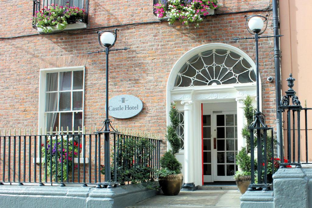 un edificio de ladrillo con una puerta y flores en él en Castle Hotel, en Dublín