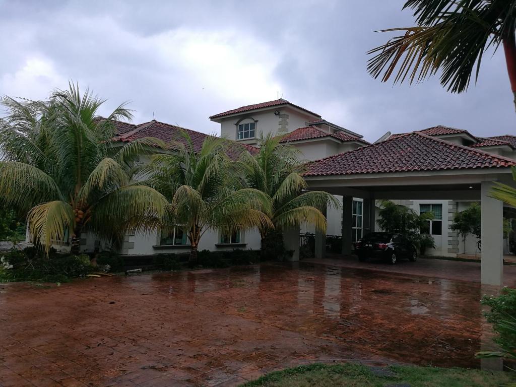 a house with palm trees in front of it at Guesthouse Dragon Place in Taiping