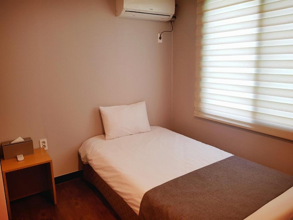 Postel nebo postele na pokoji v ubytování Hotel Tong Yeondong Jeju