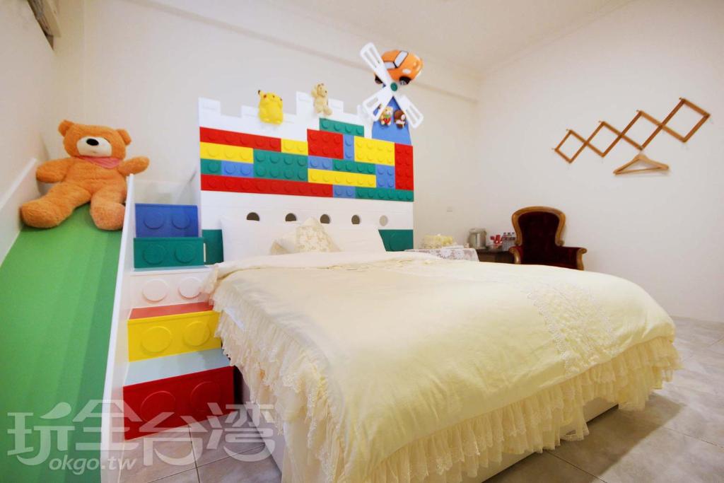 Dormitorio con cama de pie y osito de peluche en Relax heart B&B, en Dongshan