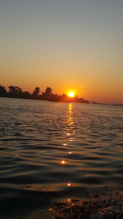 a sunset over a large body of water at Ning Ning Bungalow in Don Det