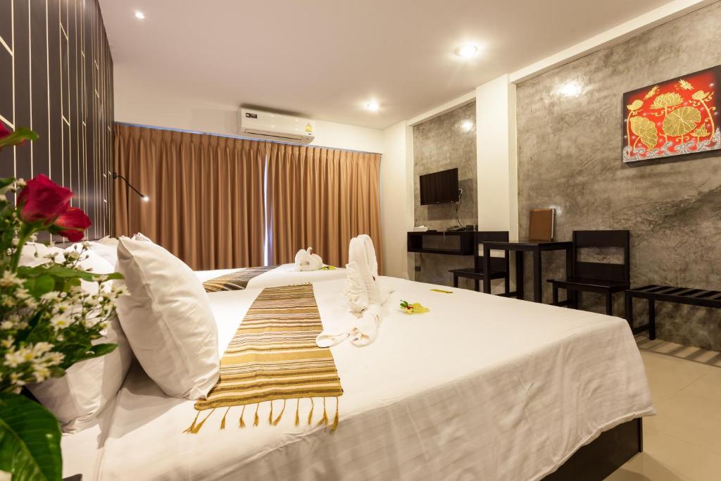 a hotel room with a bed with a towel on it at Aonang Viva Resort - SHA Plus in Ao Nang Beach