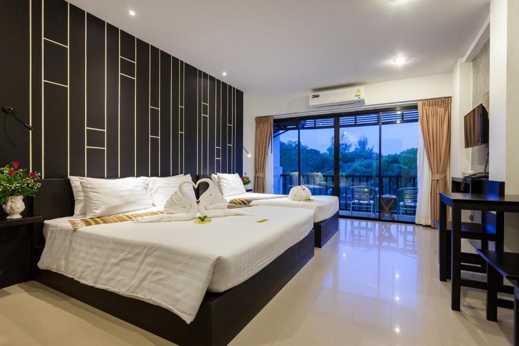 a bedroom with two beds and a balcony at Aonang Viva Resort - SHA Plus in Ao Nang Beach