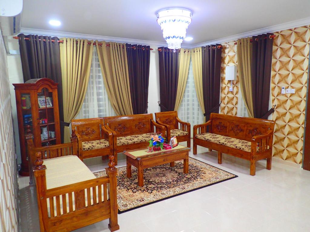 Elle comprend un salon doté d'un mobilier en bois et de rideaux. dans l'établissement RizQin Homestay Bachok, à Bachok