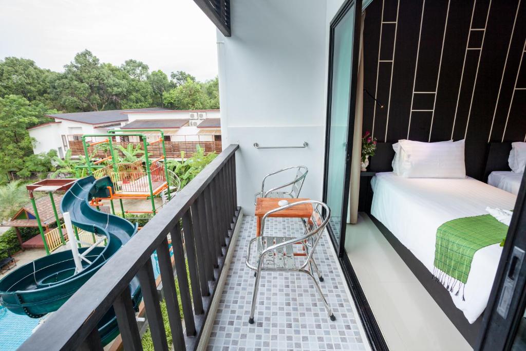 a balcony with a slide and a bed and a bedroom at Aonang Viva Resort - SHA Plus in Ao Nang Beach