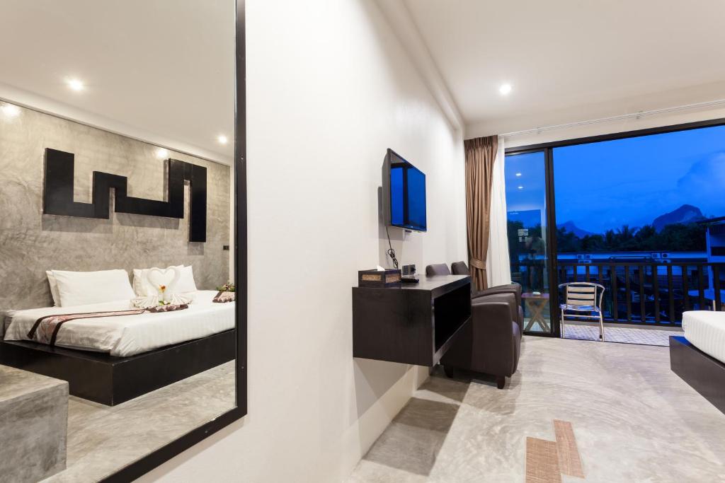 a bedroom with a bed and a mirror at Aonang Viva Resort - SHA Plus in Ao Nang Beach
