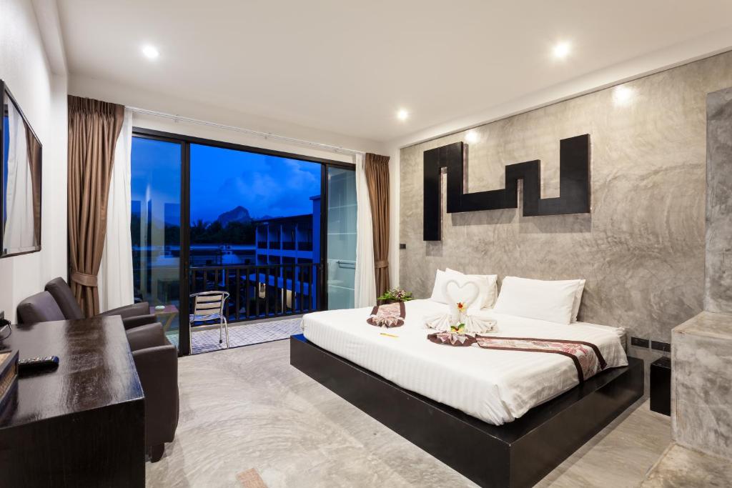 a bedroom with a king sized bed and a balcony at Aonang Viva Resort - SHA Plus in Ao Nang Beach
